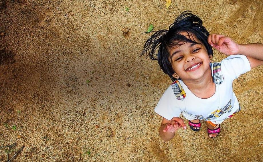 Веселая индийская девочка на пляже
