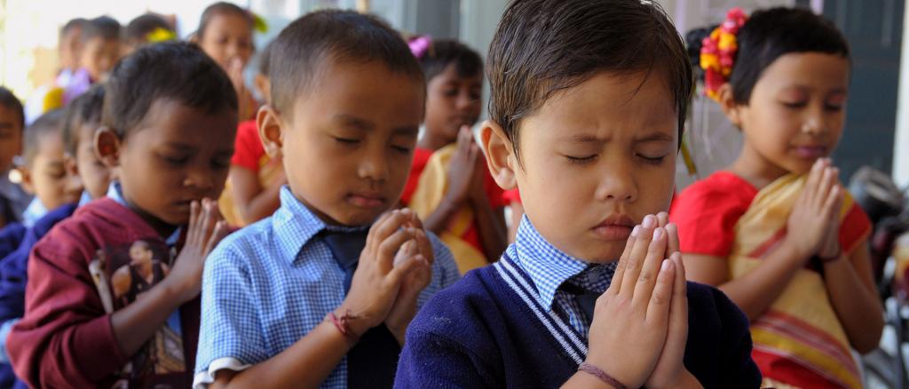 Индийские дети в традиционной молитве